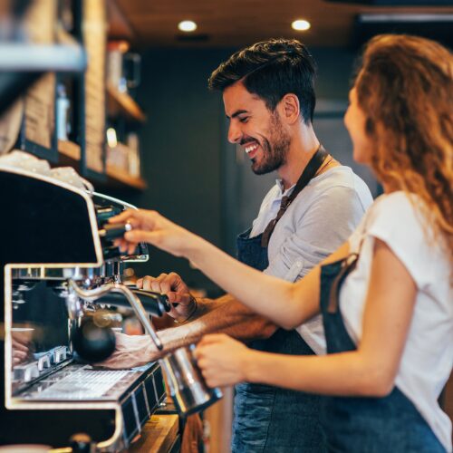 "Barista performing routine maintenance on an espresso machine, checking controls and cleaning group heads for optimal coffee extraction." "Barista performing routine maintenance on an espresso machine, checking controls and cleaning group heads for optimal coffee extraction."