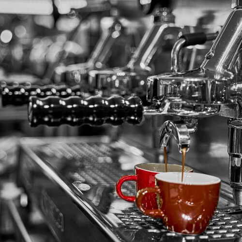 Two-group vs. three-group espresso machines side by side, illustrating their differences in size and capacity.